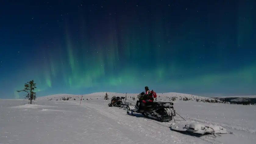 A person riding a snowmobile on a snowy surface